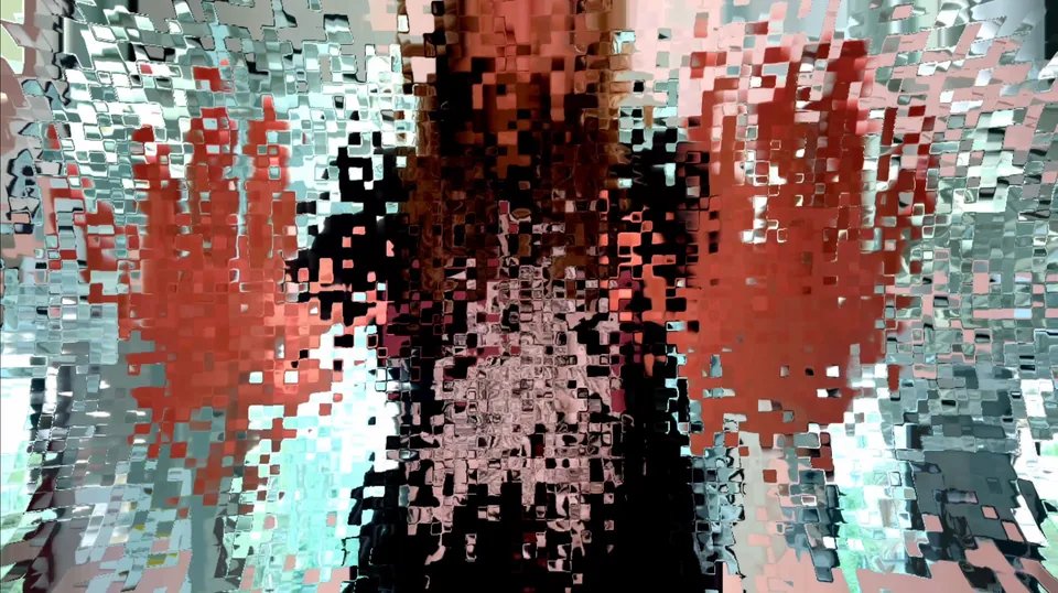 A heavily distorted image of Jake in front of a window. The distortion creates a pixel-like effect, with a slight border around each pixel creating the effect of glass tiles.